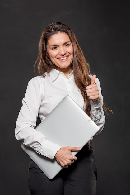 Mujer con laptop mostrando signo ok