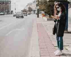 Foto gratuita mujer larga vista esperando en la estación de autobuses