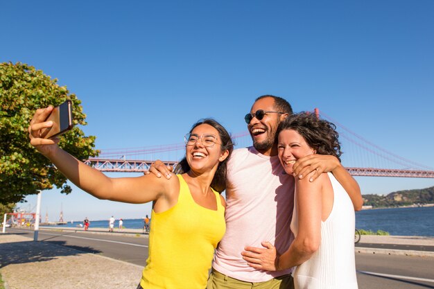 Mujer latina feliz tomando selfie grupal