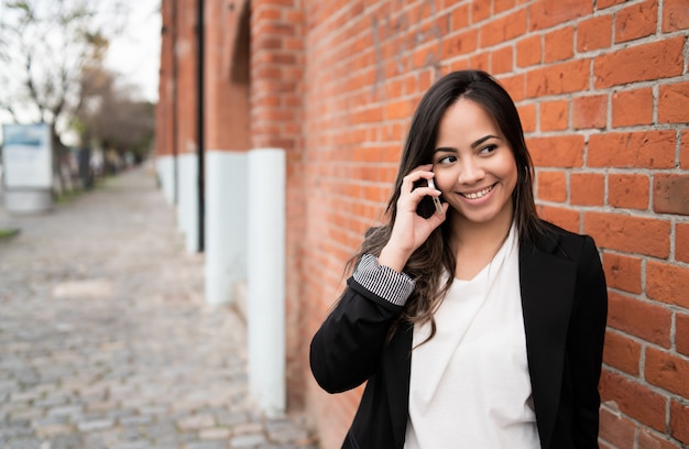 Mujer latina hablando por teléfono.