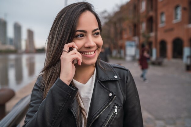 Mujer latina hablando por teléfono.