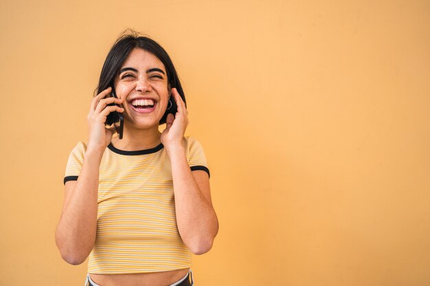 Mujer latina hablando por teléfono.