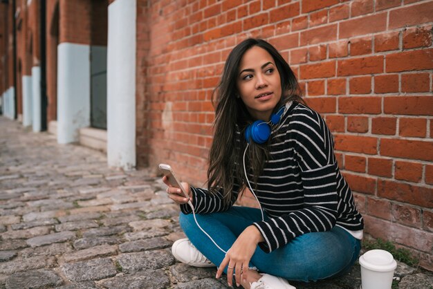 Mujer latina mediante teléfono móvil.