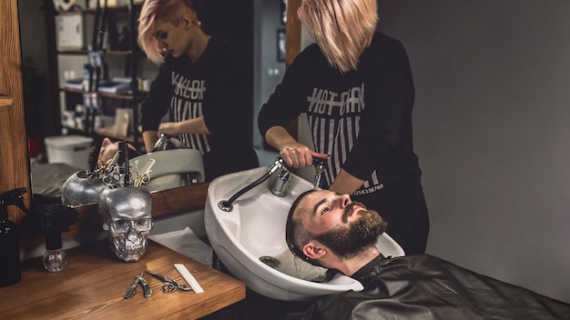 Mujer lavando el cabello al cliente