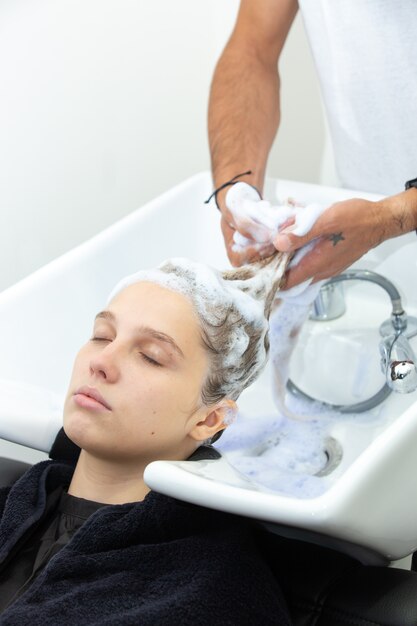 Mujer lavando el cabello con jabón