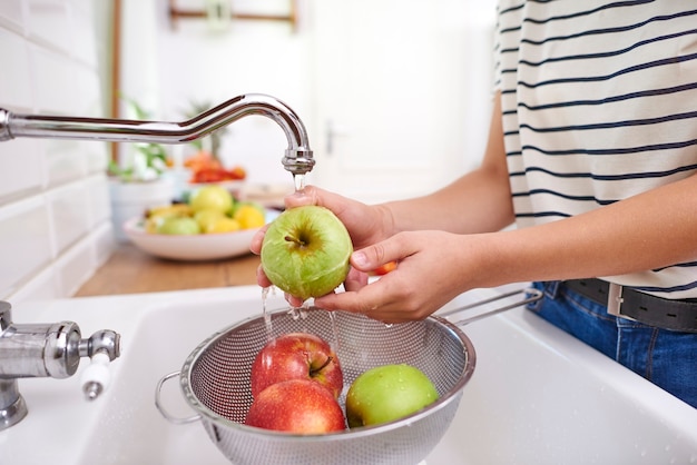 Foto gratuita mujer lavando manzanas frescas de temporada