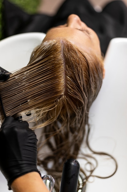 Foto gratuita mujer lavando su cabello en el salón de belleza