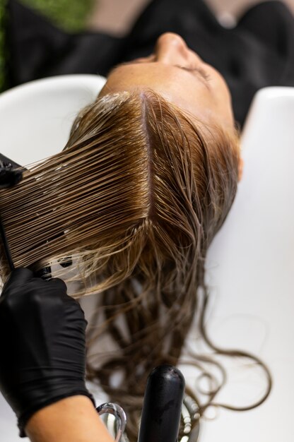Mujer lavando su cabello en el salón de belleza