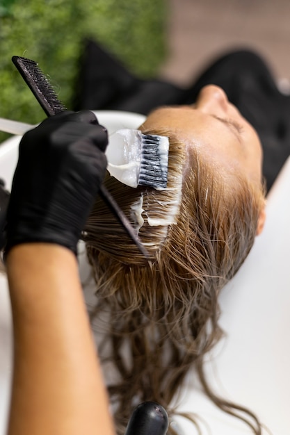 Mujer lavando su cabello en el salón de belleza