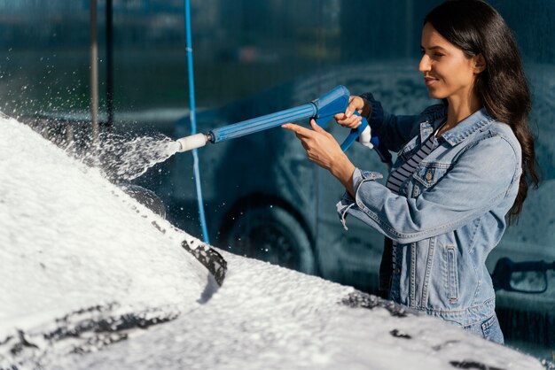 Mujer lavando su coche al aire libre