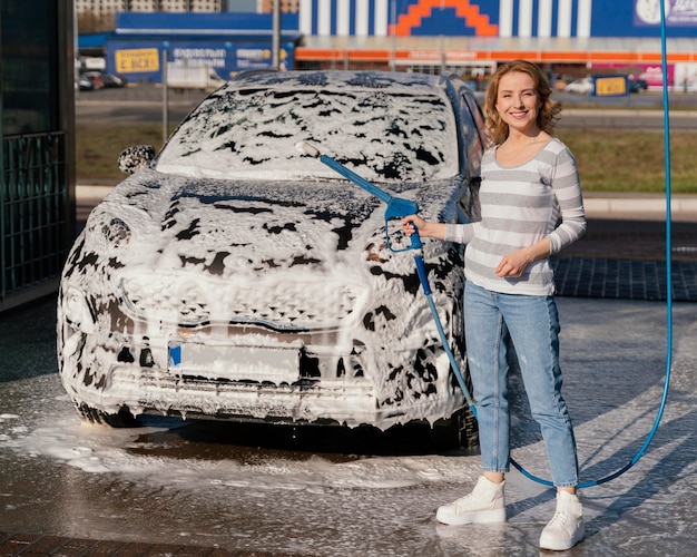 Mujer lavando su coche al aire libre