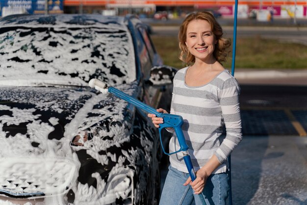 Mujer lavando su coche fuera