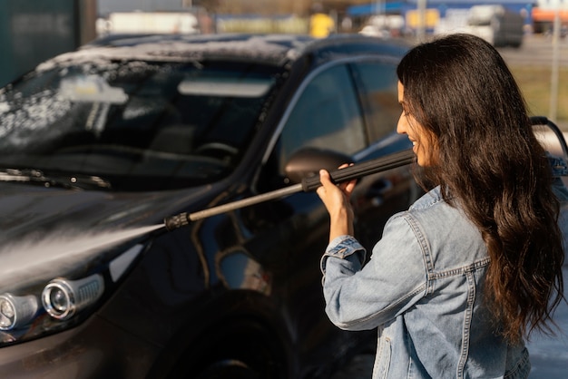 Foto gratuita mujer lavando su coche fuera