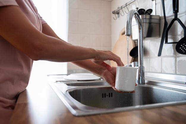 Mujer lavando su taza blanca