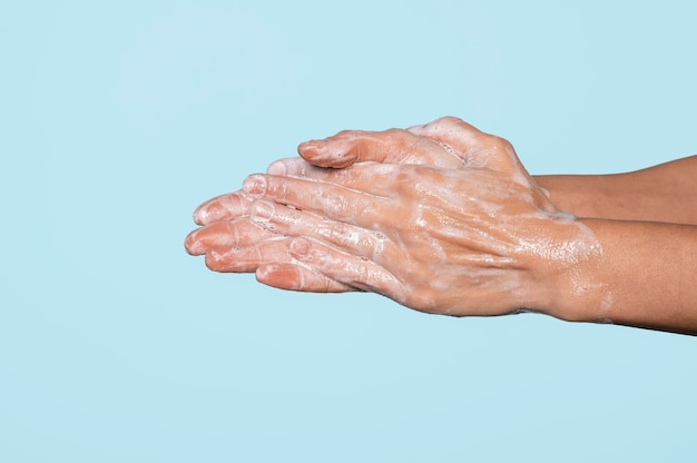 Mujer lavándose las manos aisladas en azul