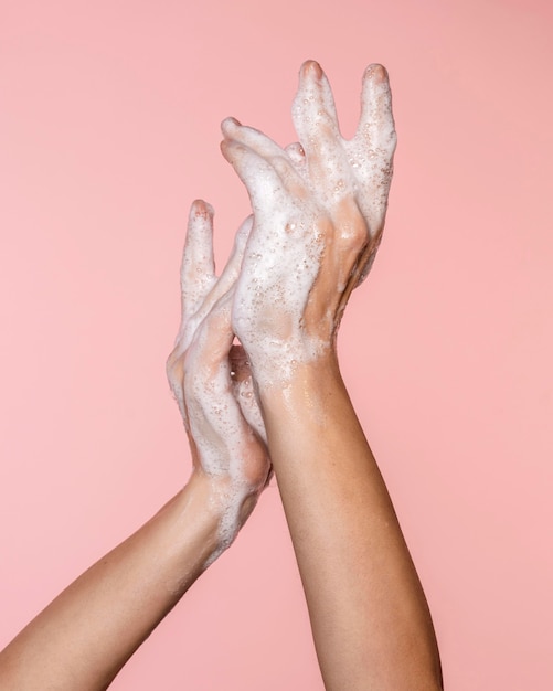 Mujer lavándose las manos aisladas en rosa