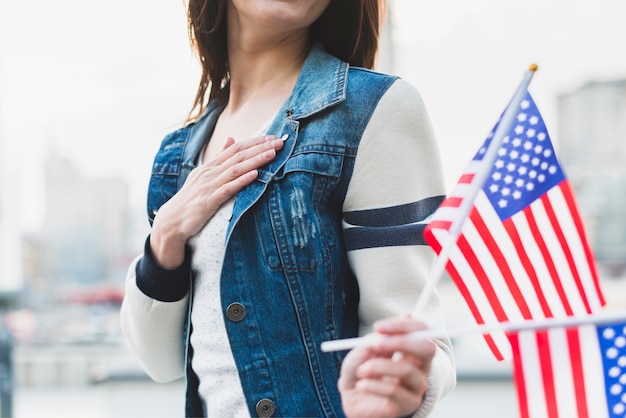 Mujer leal americana sosteniendo banderas