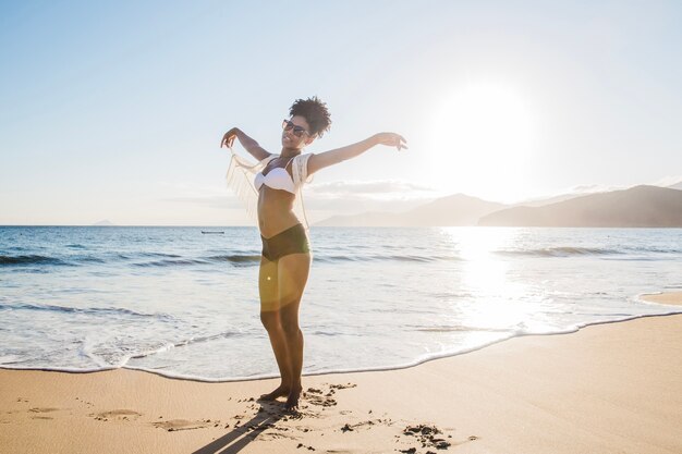Mujer levantando los brazos en la playa