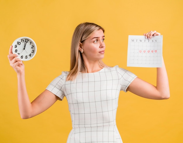 Foto gratuita mujer levantando un reloj y calendario de época