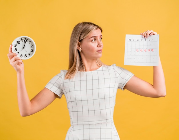 Mujer levantando un reloj y calendario de época