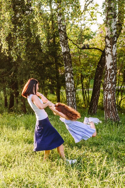 Mujer levantando a su hija en el parque