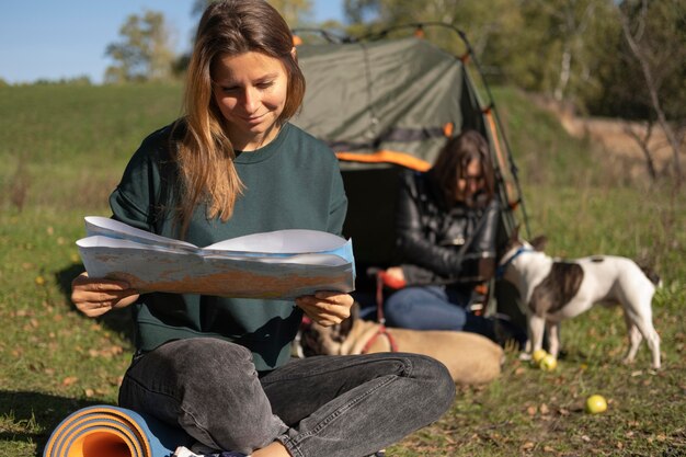 Mujer leyendo y cachorro jugando con su amiga