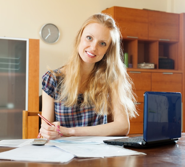 Mujer leyendo el documento financiero en la mesa