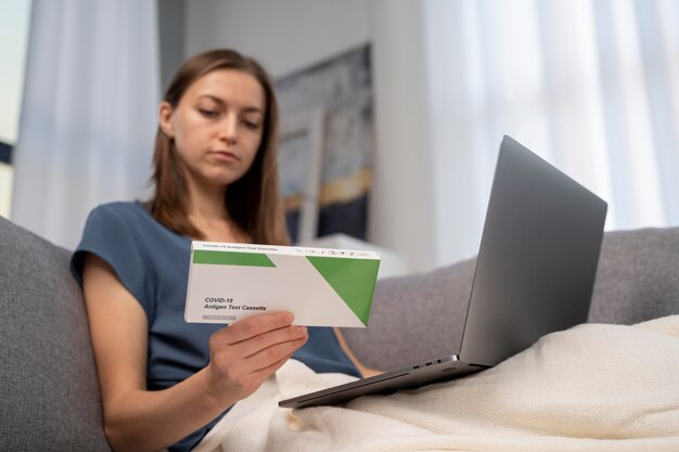 Mujer leyendo las instrucciones para una prueba de covid en casa