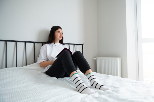 Mujer leyendo un libro en casa durante la cuarentena