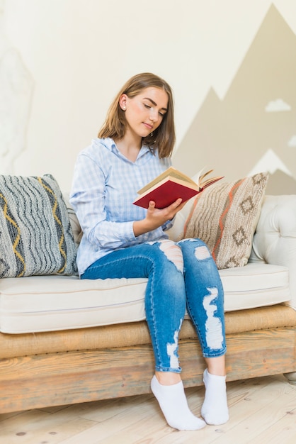 Mujer leyendo el libro en casa