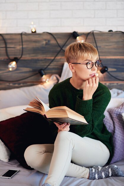 Mujer leyendo un libro en el dormitorio