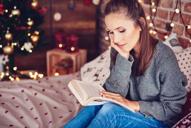 Mujer leyendo un libro en el dormitorio