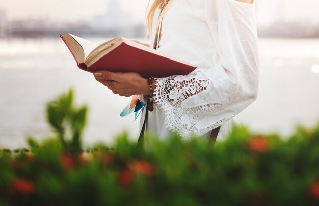 Mujer leyendo un libro junto al agua