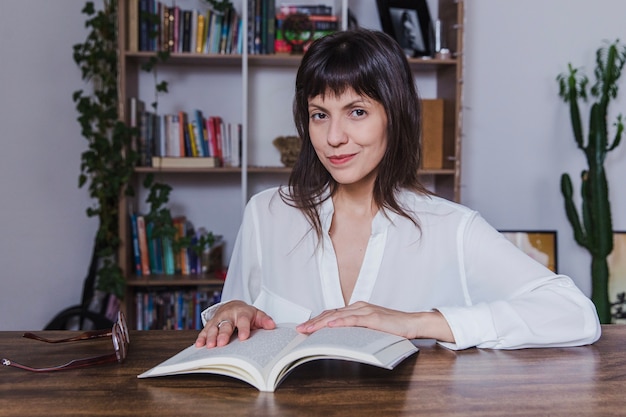 Mujer leyendo un libro en una mesa