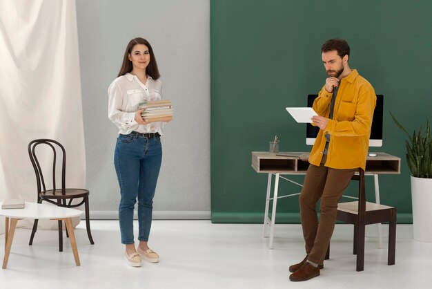 Mujer leyendo un libro mientras el hombre está usando tableta