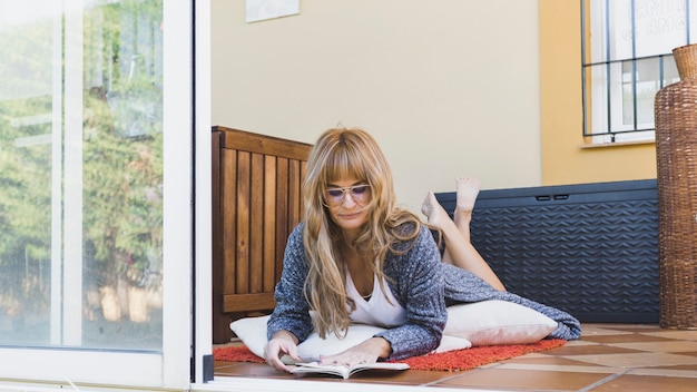 Mujer leyendo el libro en el piso