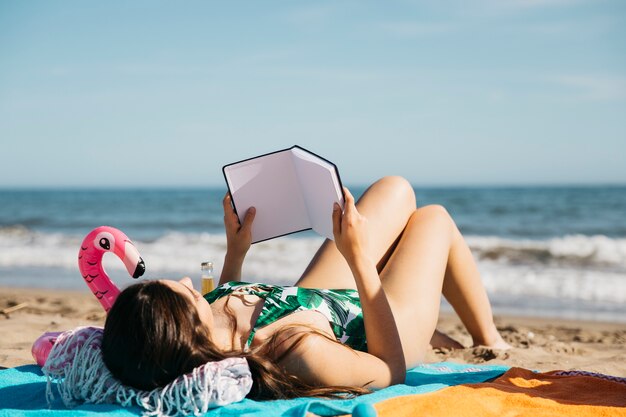 Mujer leyendo libro en la playa