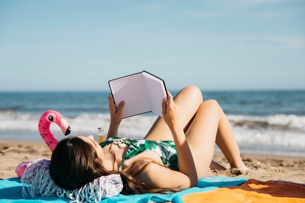 Mujer leyendo libro en la playa