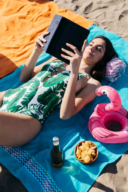 Mujer leyendo libro en la playa