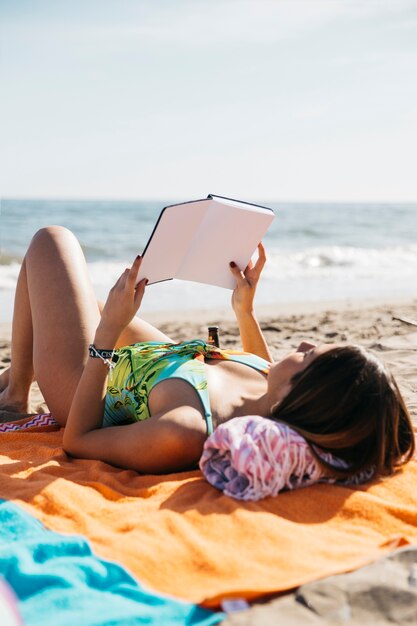 Mujer leyendo libro en la playa