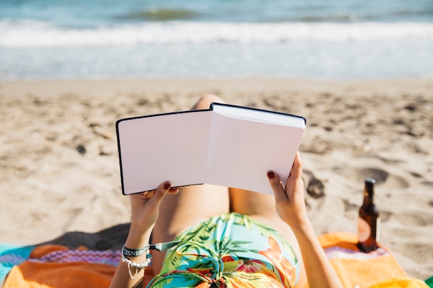 Mujer leyendo libro en la playa