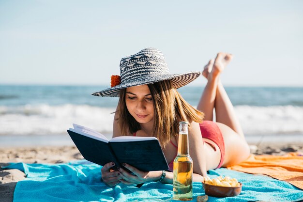 Mujer leyendo un libro en la playa