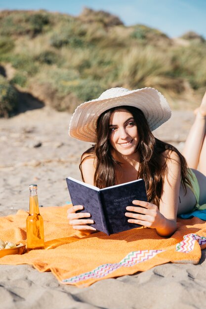 Mujer leyendo un libro en la playa