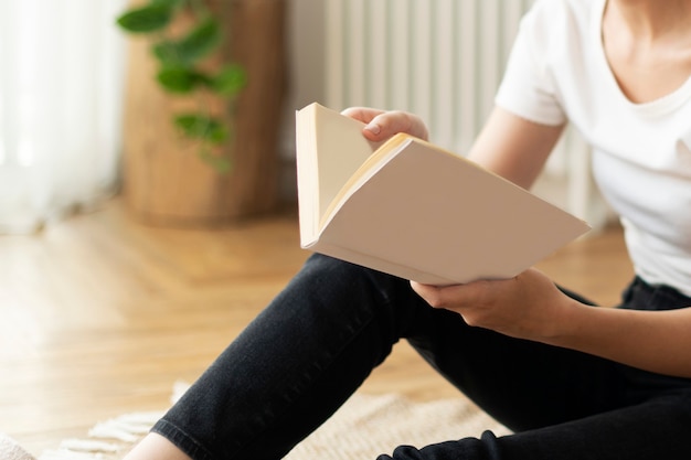 Mujer leyendo un libro sentada en el suelo