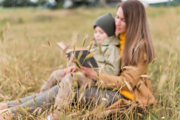 Mujer leyendo un libro a su hijo al aire libre