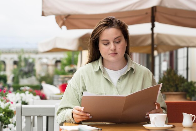 Mujer leyendo menú plano medio