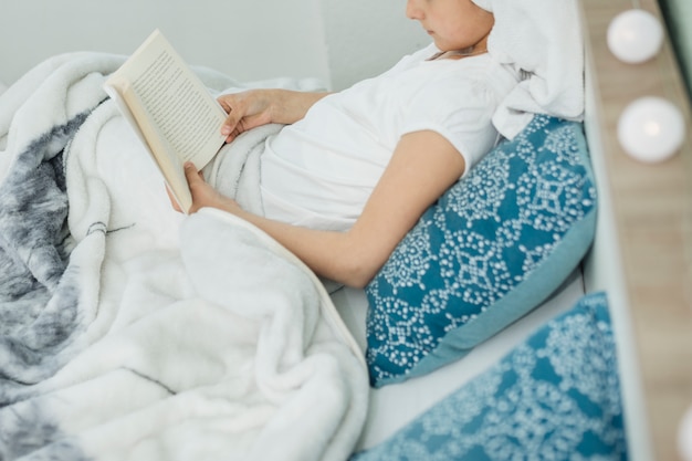 Mujer leyendo mientras está en la cama