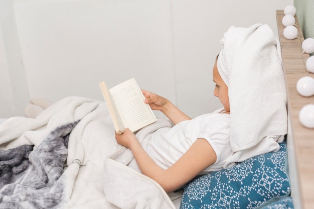 Mujer leyendo mientras está en la cama