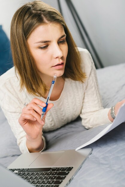 Mujer leyendo papeles y pensando