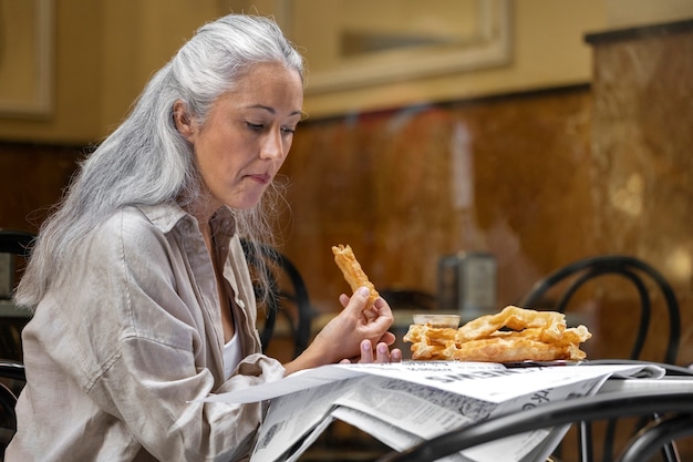 Mujer leyendo la vista lateral del periódico